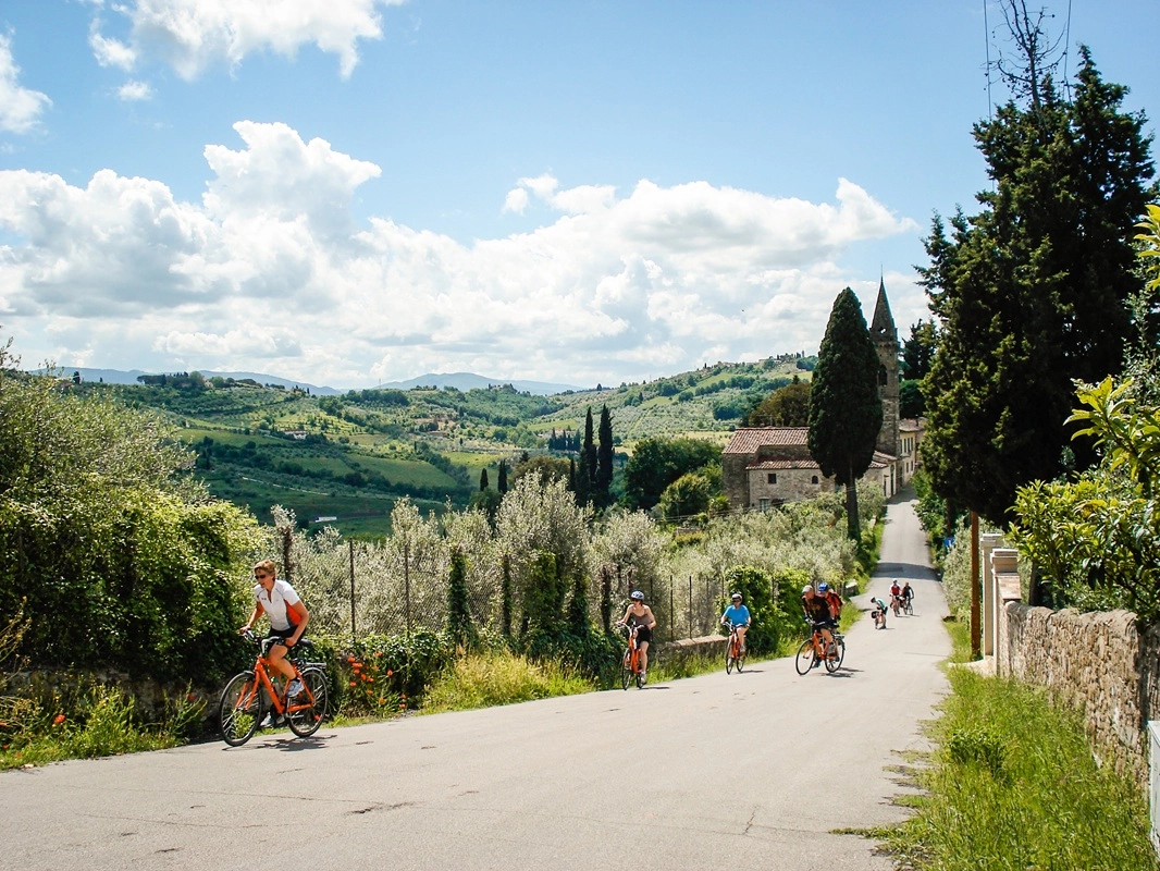 Fietser door Toscaanse heuvels met wijngaarden onderweg van Pisa naar Casciana Terme tijdens een fietsvakantie in Toscane
