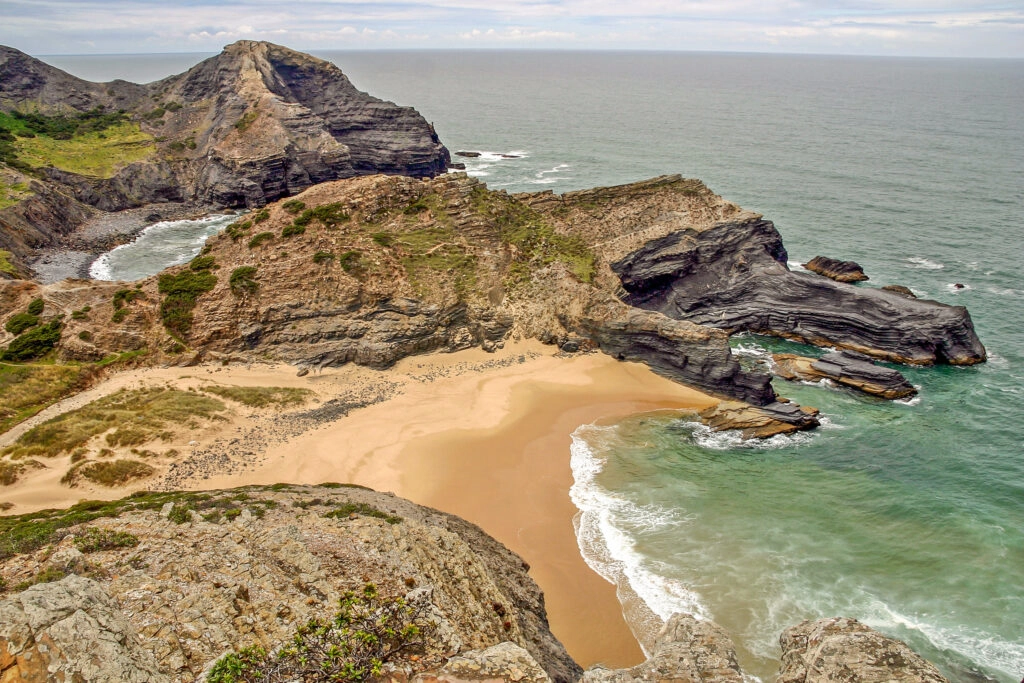 Dramatische kliffen en afgelegen zandbaai bij Cabo Sardão langs de Fisherman’s Trail in Portugal.