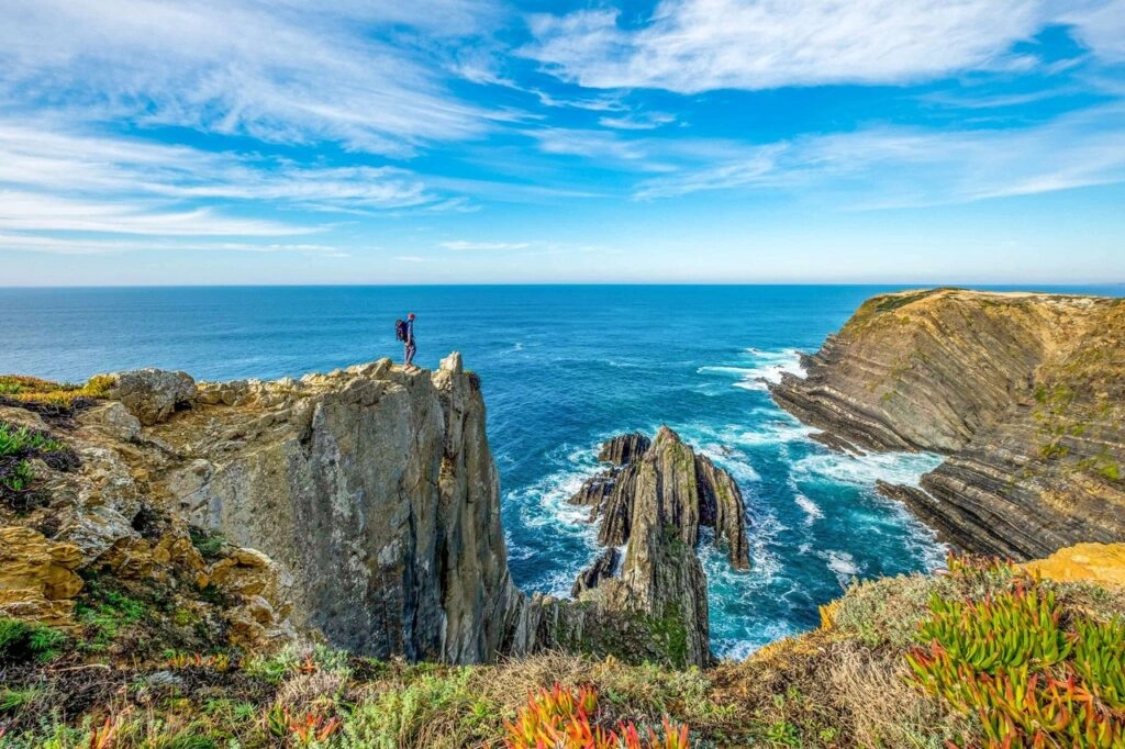 Wandelaar op de kliffen van de Fisherman’s Trail langs de Atlantische Oceaan in Portugal – onderdeel van de Rota Vicentina tussen Alentejo en Algarve.
