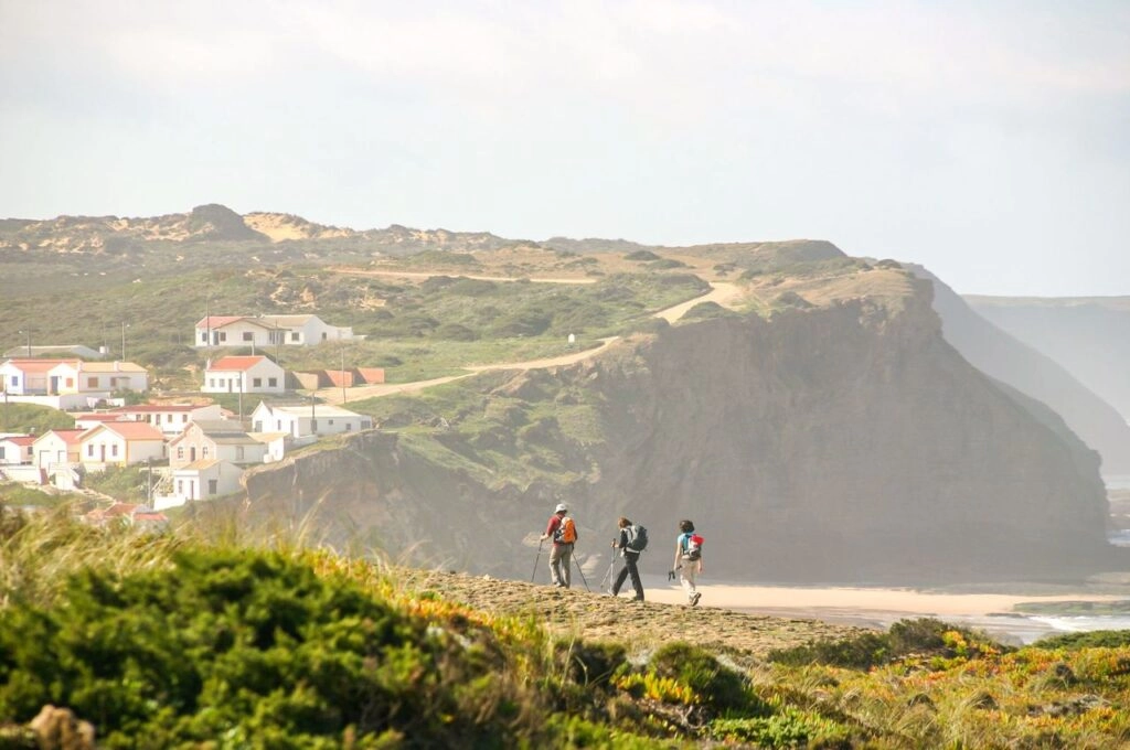 Wandelaars volgen de Fisherman’s Trail langs de kliffen en witte vissershuisjes aan de Costa Vicentina in Portugal.