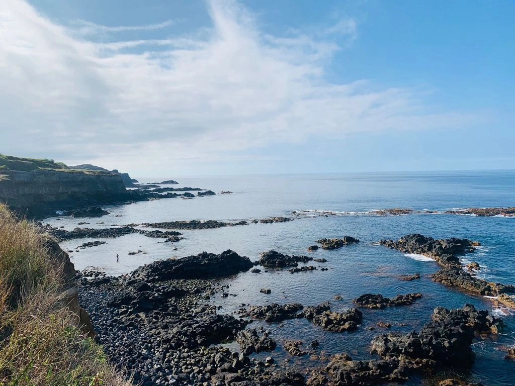 Rotsachtige vulkanische kustlijn op de Azoren met helderblauwe oceaan en kliffen, gezien tijdens een wandelroute.