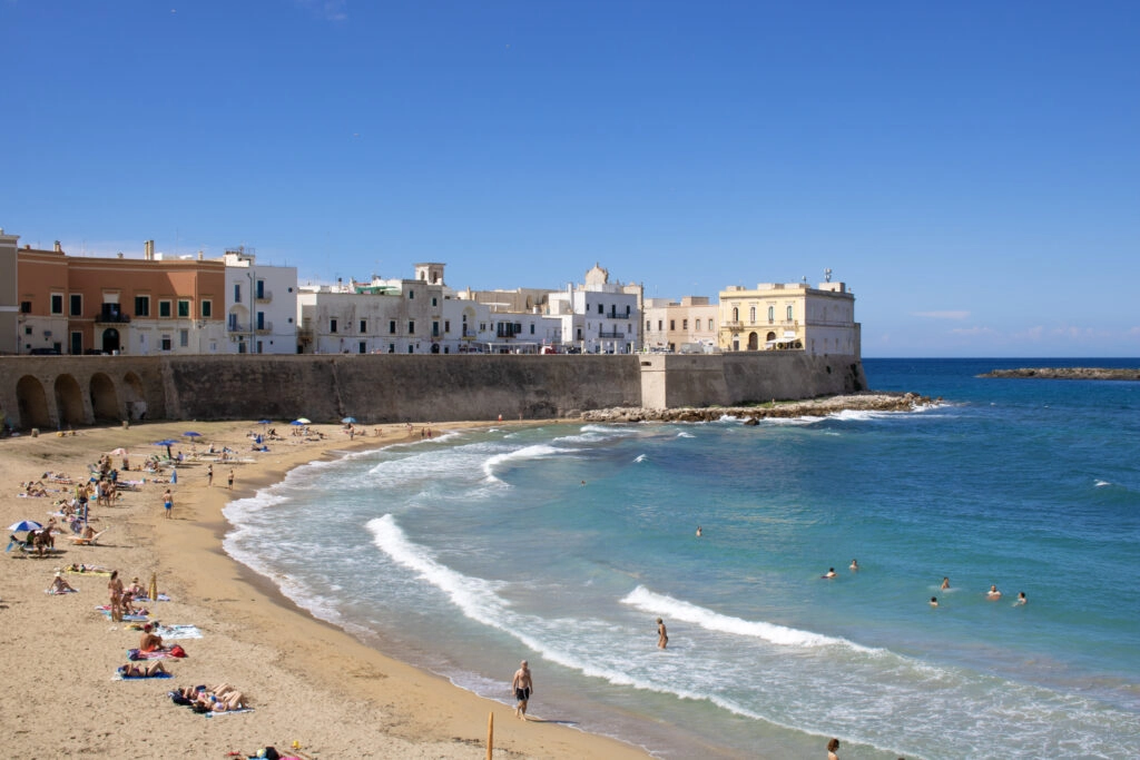 Strand en oude stadsmuren van Gallipoli aan de Ionische Zee – historische kustplaats in Salento, Zuid-Italië