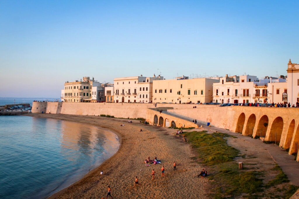 Gallipoli bij zonsondergang met strand Spiaggia della Purità en oude stadsmuren – Salento, Puglia