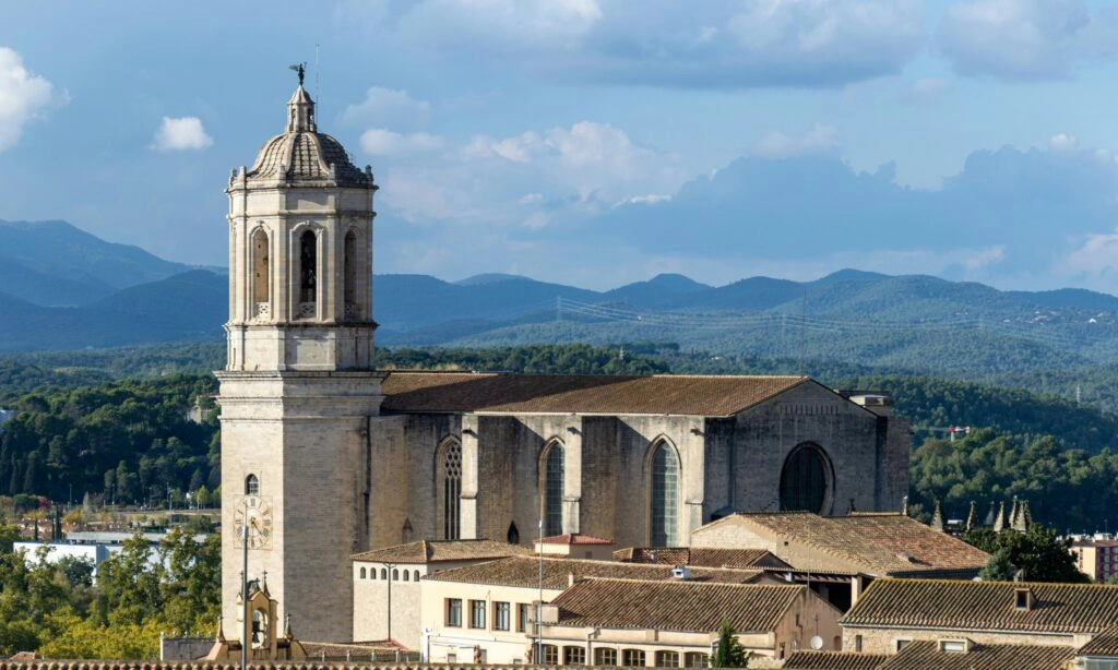 Uitzicht op de kathedraal van Girona met berglandschap op de achtergrond.