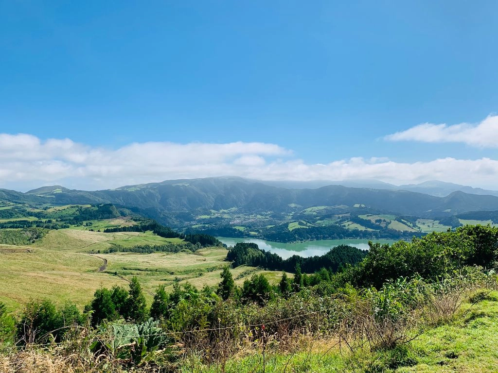 Panoramisch uitzicht op Lagoa das Furnas, een groen kratermeer omringd door heuvels, bossen en vulkanisch landschap op São Miguel, Azoren