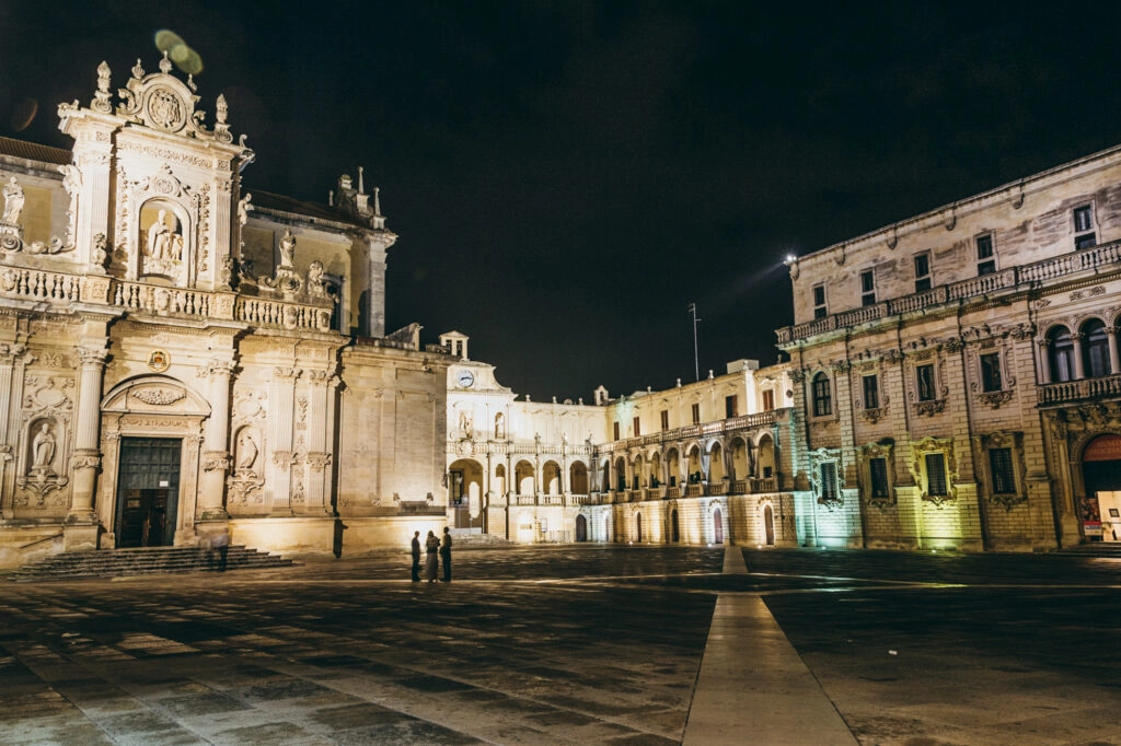 Avondfoto van het Piazza del Duomo in Lecce, Italië, met verlichte barokke gevels en rustige sfeer tijdens een fietsvakantie in Puglia.
