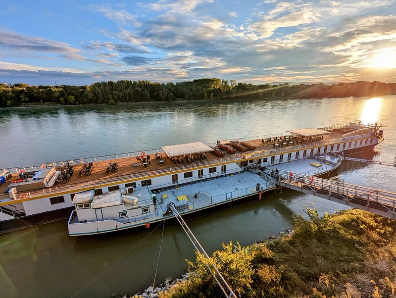 MS Prinzessin Katharina aangemeerd aan de Donau bij zonsondergang, met zicht op het zonnedek en fietsen aan boord.