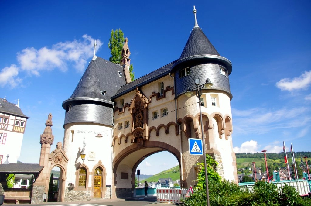 Brückentor van Bernkastel-Kues aan de Moezel, karakteristieke stadspoort met torens en uitzicht op wijnhellingen – hoogtepunt tijdens een fiets- en vaarvakantie langs de Moezel