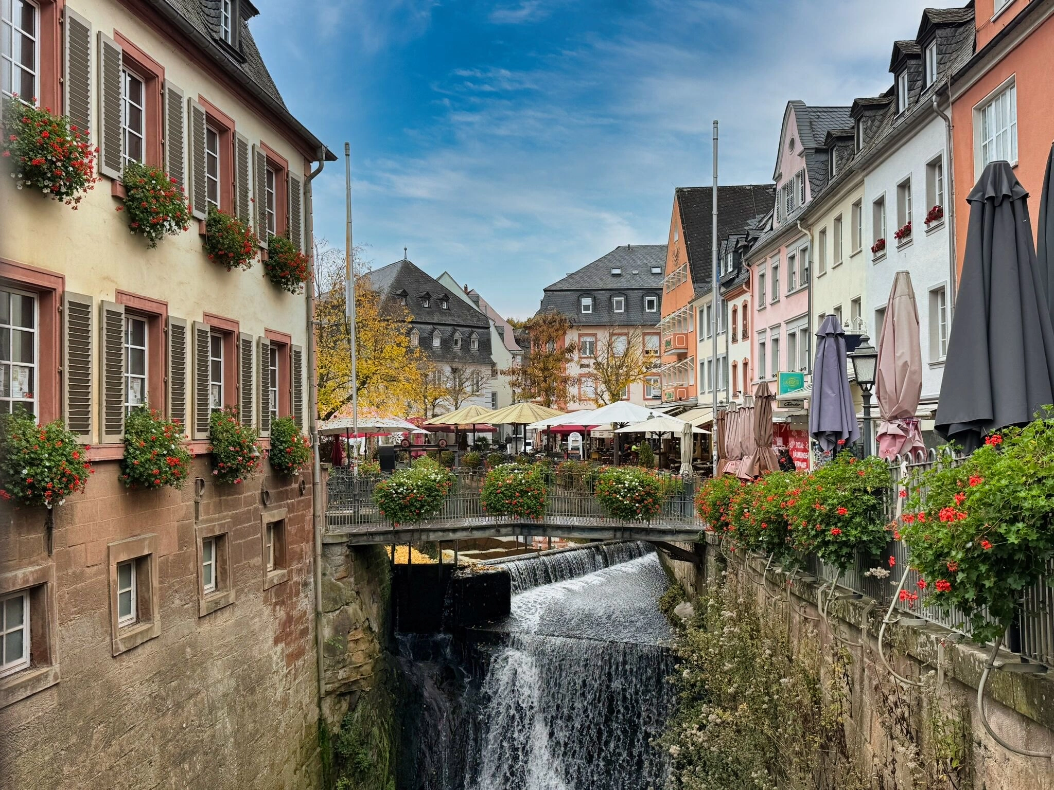 Historisch centrum van Saarburg met de beroemde waterval, kleurrijke gevels en terrasjes langs het water – sfeervolle startplaats van de fiets- en vaarvakantie over Saar en Moezel