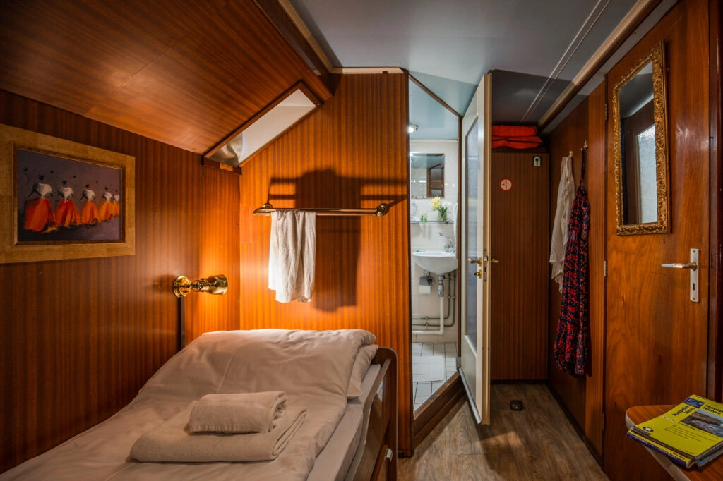 Knusse eenpersoonshut op L’Estello met houten interieur, frisse badkamer en praktische opbergruimte tijdens een fiets- en vaarvakantie in de Provence.