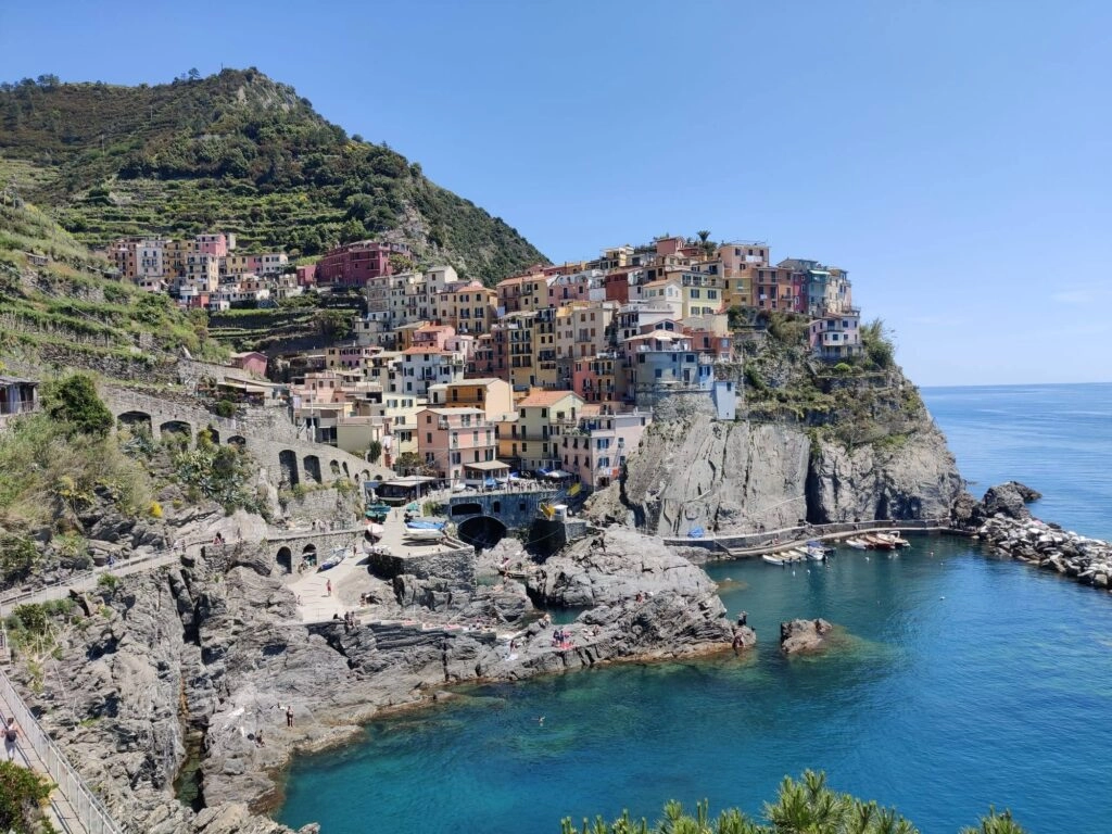 Panoramisch uitzicht op Manarola met kleurrijke huizen op de kliffen boven de Middellandse Zee, een hoogtepunt van de wandelreis door de Cinque Terre.