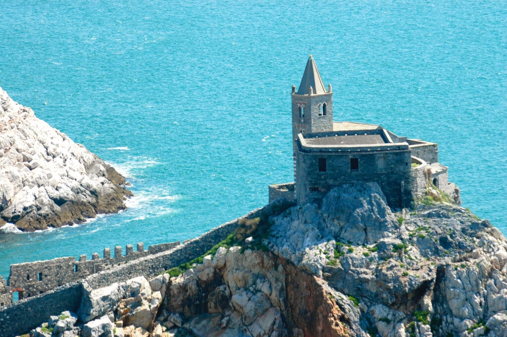San Pietro-kerk van Portovenere op de rotsen aan de Ligurische kust, met uitzicht over de turquoise Middellandse Zee.