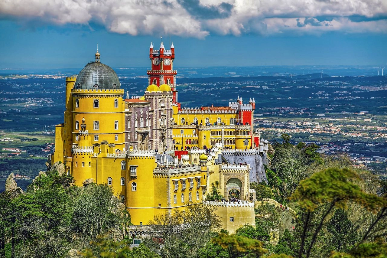 Het kleurrijke Palácio da Pena in Sintra met gele en rode torens, hoog boven het bos met panoramisch uitzicht over de regio.