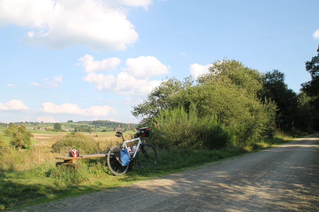 Rustpunt langs de Vennbahn met fiets en uitzicht over glooiende heuvels in de Ardennen