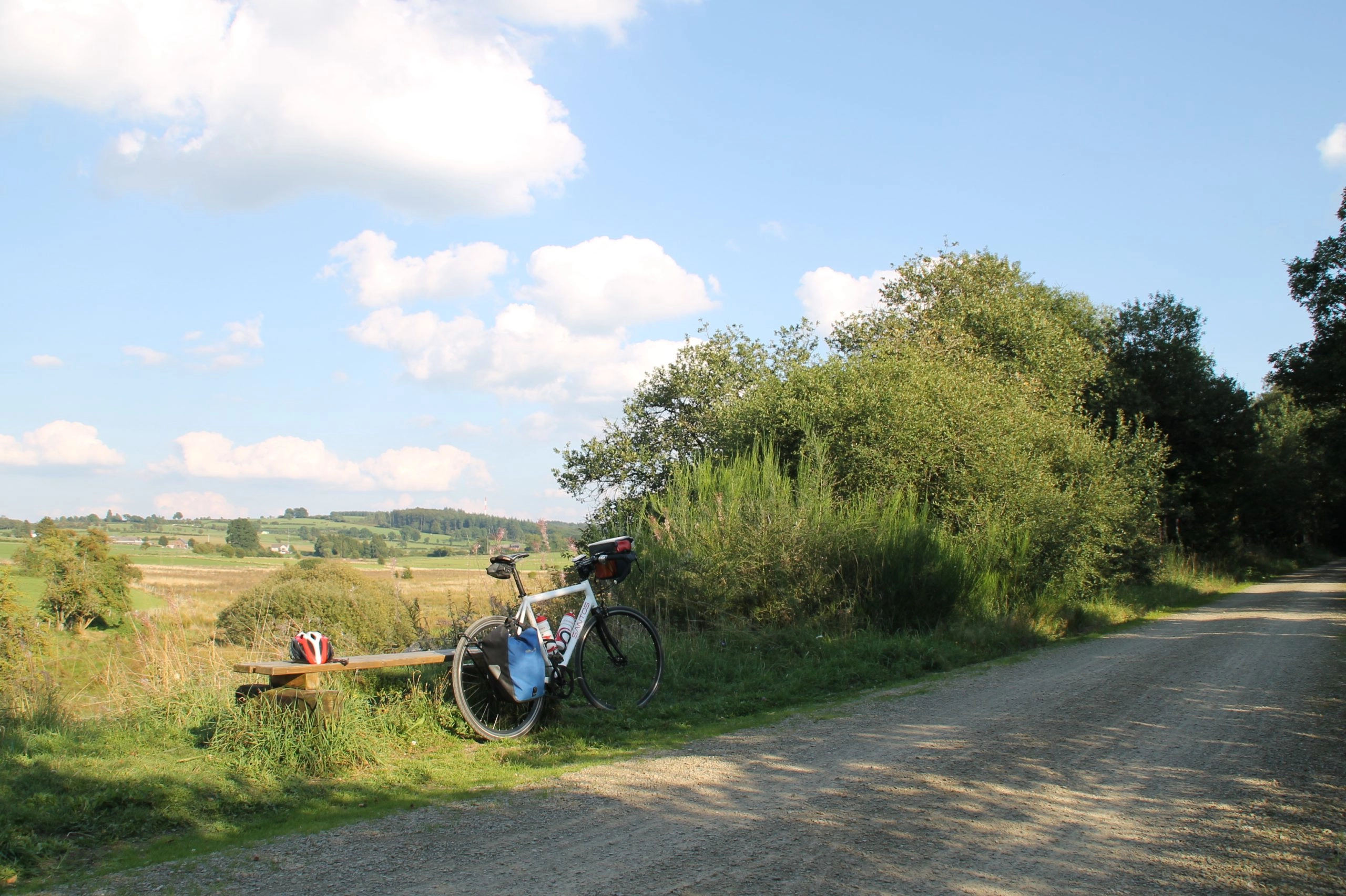 Rustpunt langs de Vennbahn met fiets en uitzicht over glooiende heuvels in de Ardennen