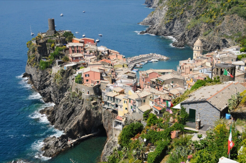 Panoramisch uitzicht op Vernazza met kleurrijke huizen, de middeleeuwse toren en de haven, een hoogtepunt van de Cinque Terre wandelreis.