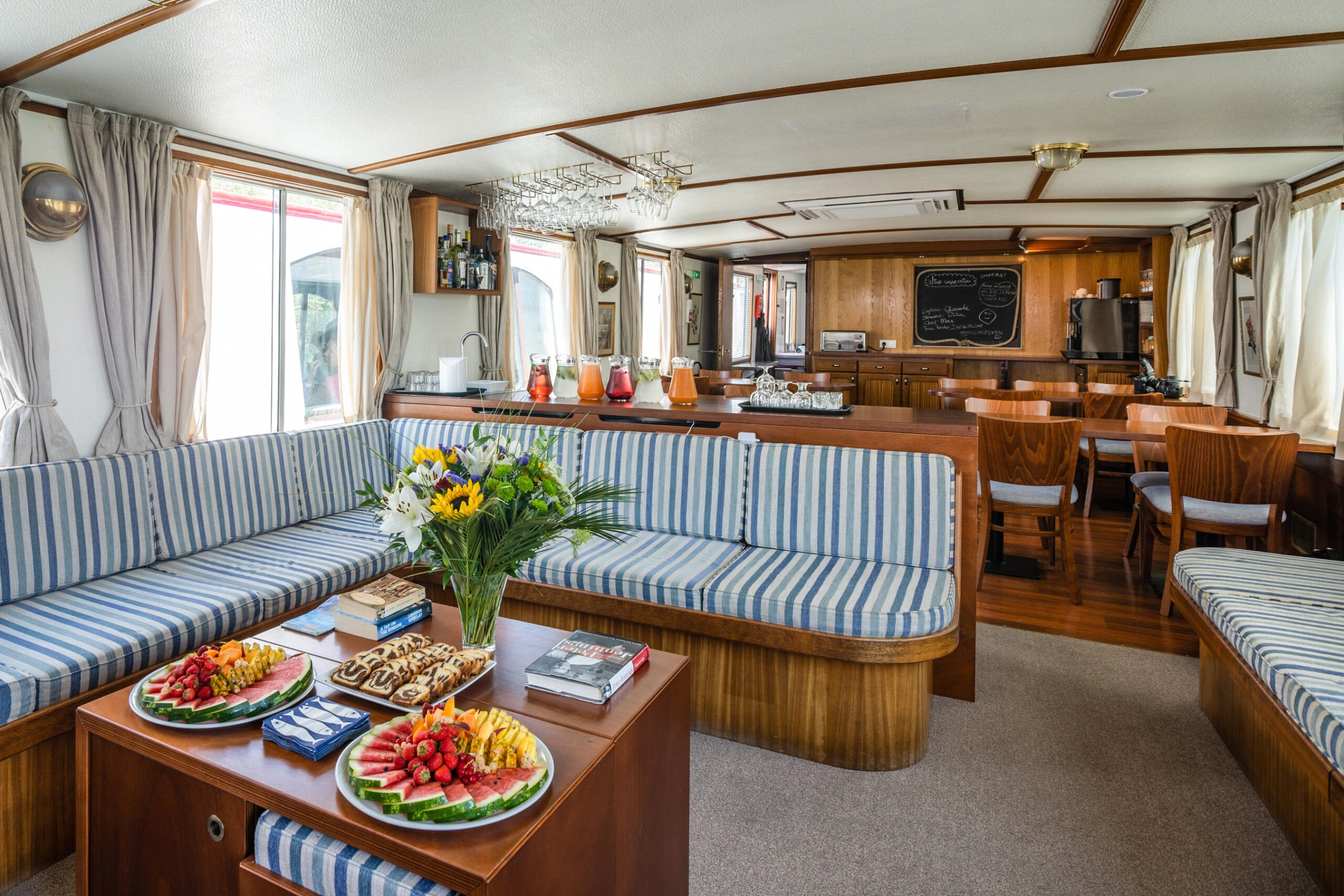 Cosy lounge and dining area on board the cruise ship Caprice with snacks, drinks and comfortable seating