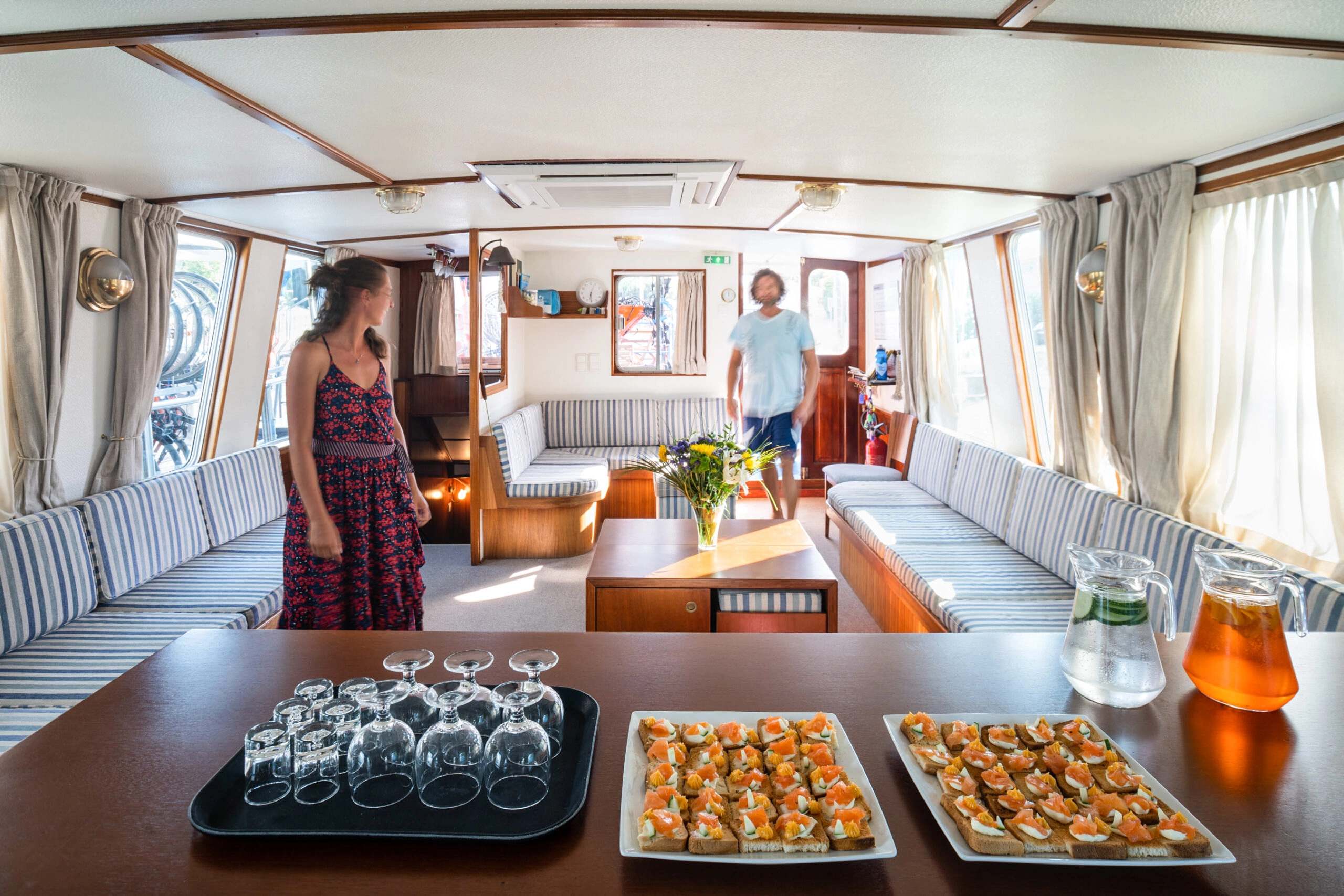 Lounge on board the cruise ship Caprice with two guests and a table with snacks and drinks