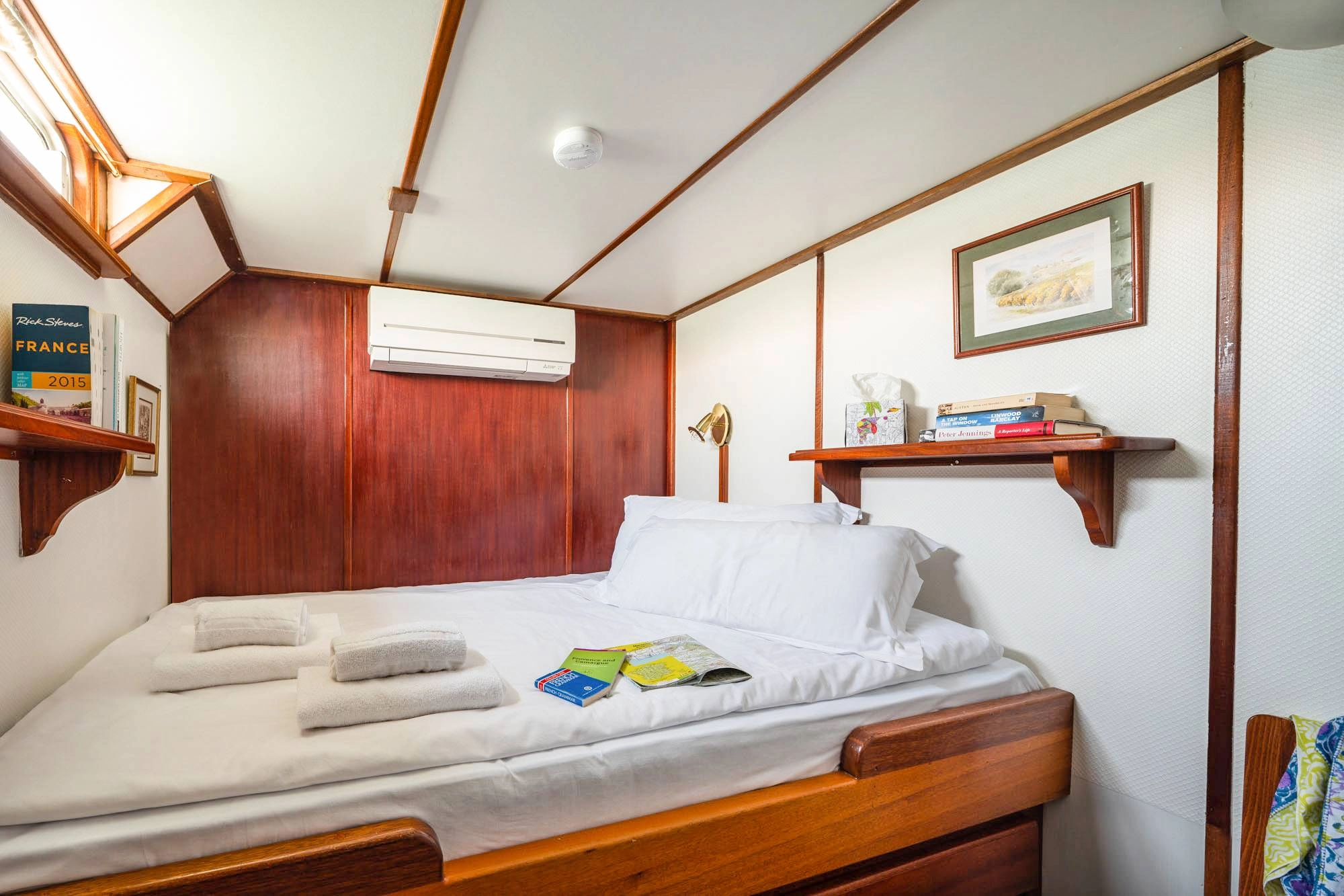 Double cabin with a double bed on board the cruise ship Caprice, featuring a wooden interior and air conditioning