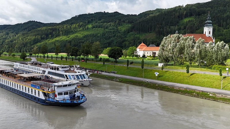 Cruise ships on the Danube near Engelhartszell, with Engelszell Abbey in the Danube valley — starting point of the bike and barge holiday.