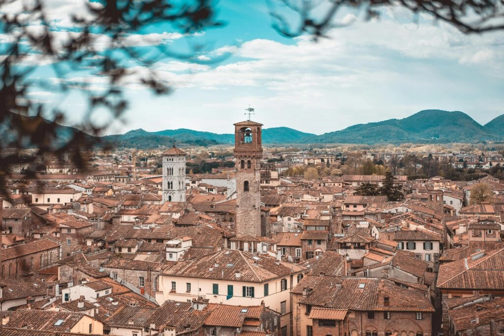 Panoramisch uitzicht over Lucca met middeleeuwse torens, oranje daken en Toscaanse heuvels op de achtergrond
