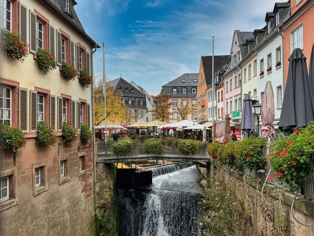Historisch centrum van Saarburg met de beroemde waterval, kleurrijke gevels en terrasjes langs het water – sfeervolle startplaats van de fiets- en vaarvakantie over Saar en Moezel