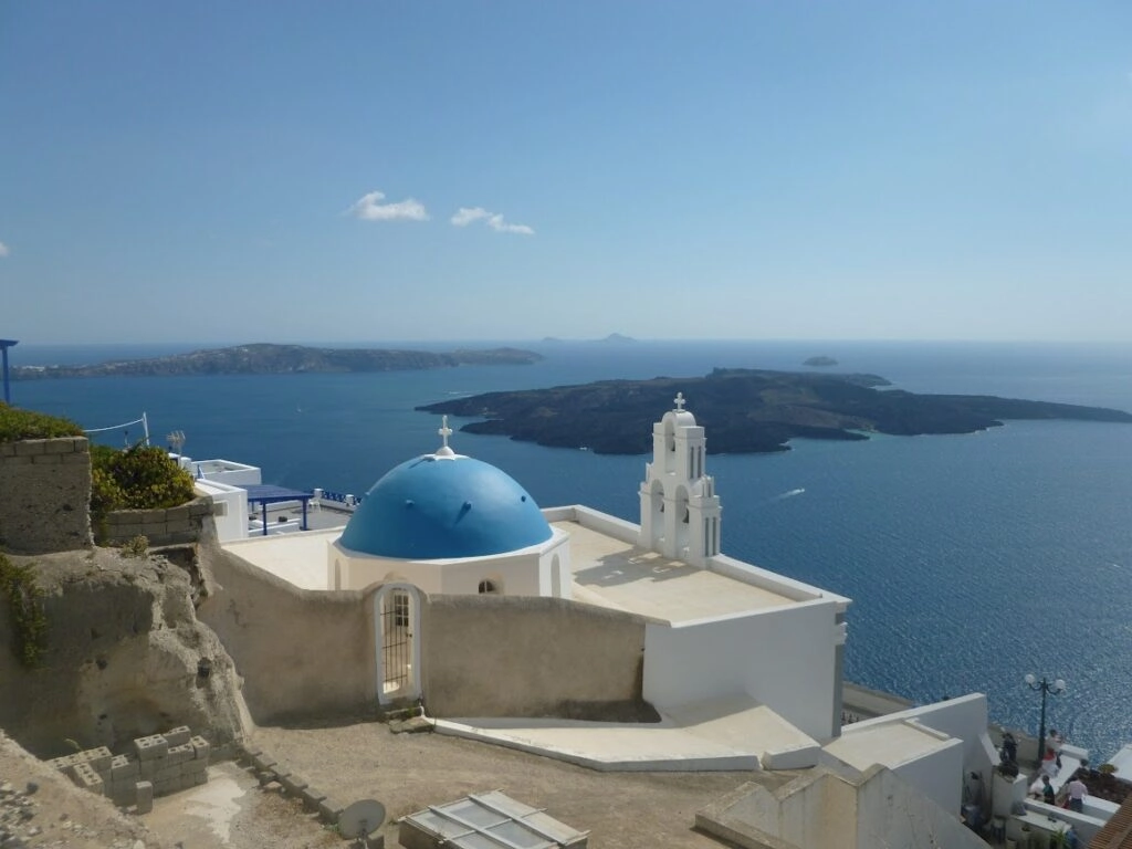 Uitzicht op Santorini caldera met wit-blauw Grieks kerkje tijdens self-guided wandelreis Naxos en Santorini