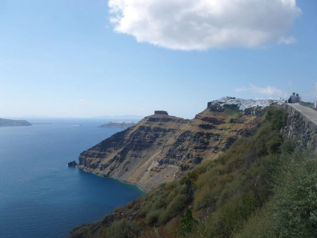 Wandelpad langs de caldera van Santorini met uitzicht op steile kliffen, zee en witte dorpjes