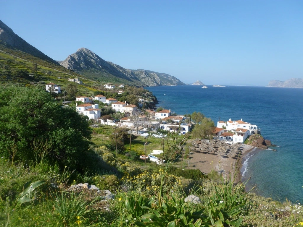 Kustdorp op Poros met uitzicht op zee en bergen tijdens een wandelvakantie in Griekenland